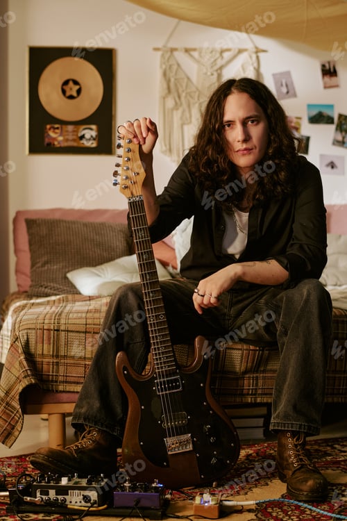 Preview: Portrait of Long Haired Man Holding Electric Guitar at Home Studio