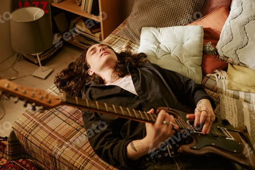 Preview: Long Haired Man Playing Electric Guitar at Home for Music Lifestyle