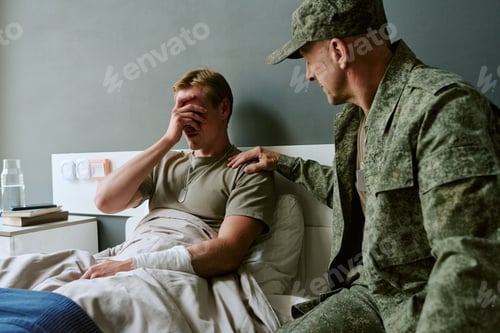 Preview: Young Adult Man Recovering in Military Hospital Receiving Emotional Support