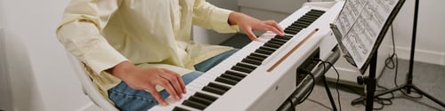 Preview: Website banner of teenager playing violin while teacher guiding arm position during music lesson. Su