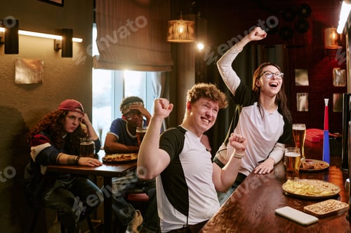 Preview: Diverse Sports Fans Celebrating Win While Watching Match in Bar