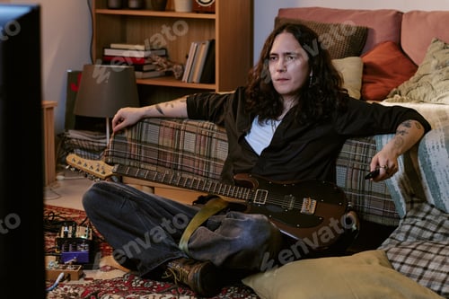 Preview: Long Haired Man Musician Relaxing at Home with Electric Guitar