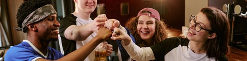 Preview: Diverse Teenagers Fist Bumping in Cafe for Team Bonding