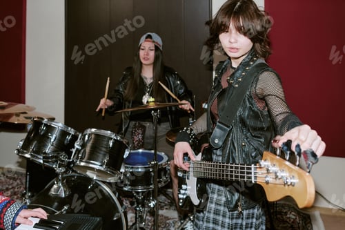 Preview: Teenage Girls Tuning Bass Guitar during Music Band Practice Session