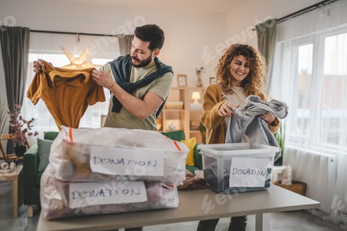 Preview: Couple Stand at Home Choose Clothes for Donation Sorting Wardrobe