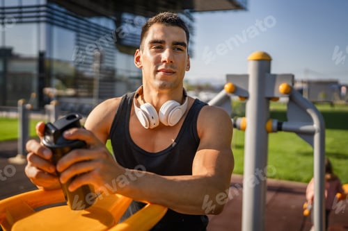 Preview: One caucasian man young male athlete take a brake during outdoor training in the park outdoor gym ho