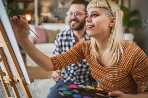 Preview: Couple Man and Woman Paint on Canvas on Easel at Home Leisure Hobby