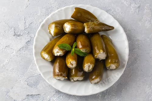 Preview: Pickled Jalapeno Peppers Stuffed with Cream Cheese Served on a White Plate
