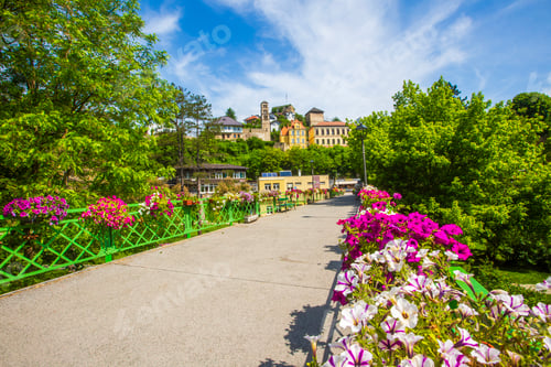 Preview: Scenic pedestrian bridge decorated with colorful flowers overlooking old town in Jajce, Bosnia and H