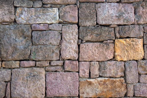 Preview: Rustic old stone wall texture with brown pink and yellow bricks in a traditional historical building