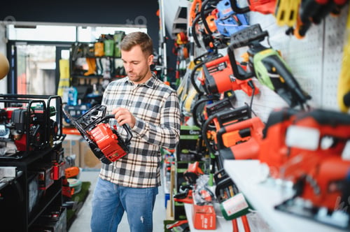 Preview: Man is choosing electric saw in tools store