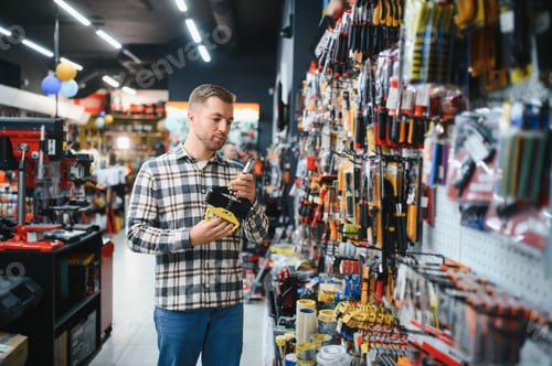 Preview: A male buyer in a modern hardware store. A large selection of tools and various household and constr