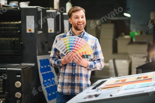 Preview: Printing worker holding color palette in printing house