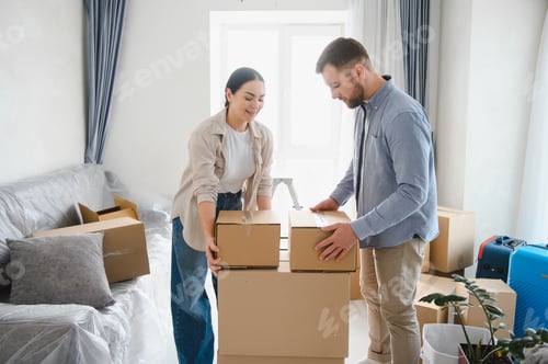 Preview: Couple moving into new home carrying cardboard boxes