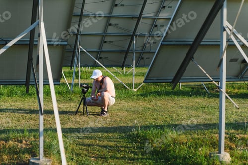 Preview: Person filming under solar panels researching renewable energy