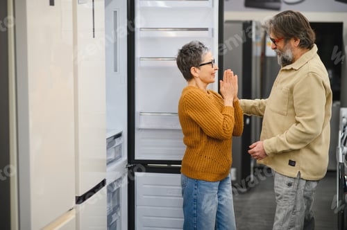 Preview: Senior couple choosing new refrigerator in appliance store