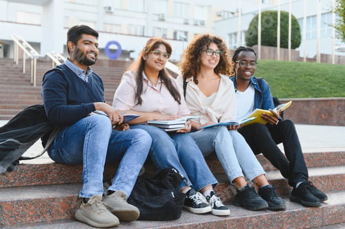 Preview: Diverse students sitting on campus stairs studying together