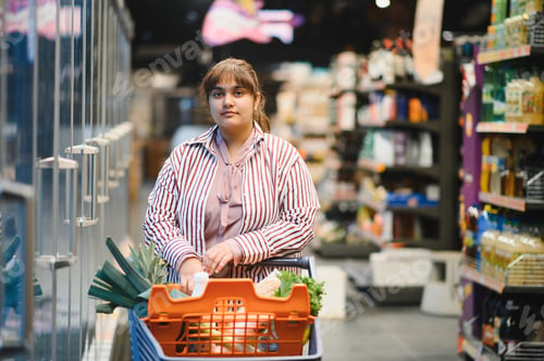 Preview: Indian woman pushing shopping cart in grocery store