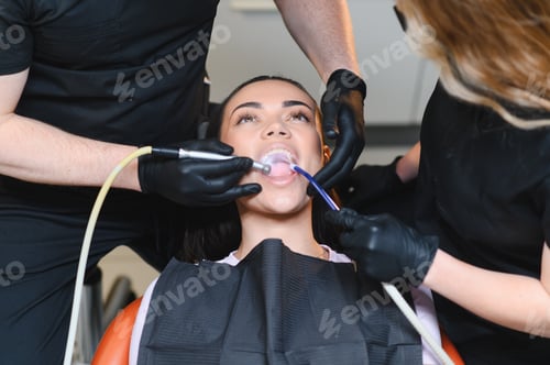 Preview: Dentist team assisting patient during professional teeth cleaning