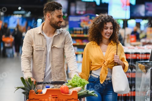 Preview: Happy couple enjoying grocery shopping in supermarket
