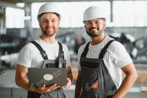 Preview: Two Heavy Industry Employees in Hard Hats Discussing Job Assignments at the Factory, Using Laptop Co