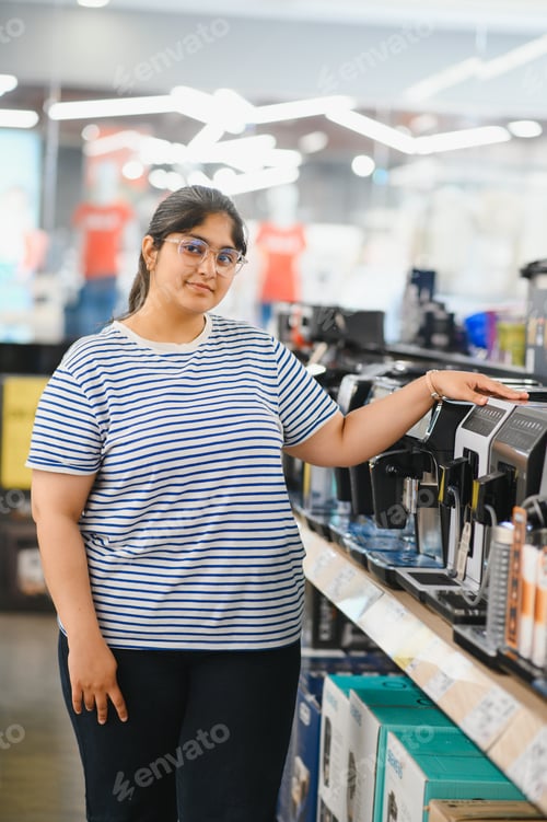 Preview: Smart modern female customer choosing coffee machine at electronics store