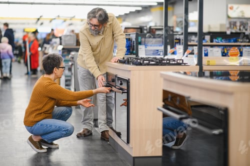Preview: Mature couple choosing new kitchen appliances together in store