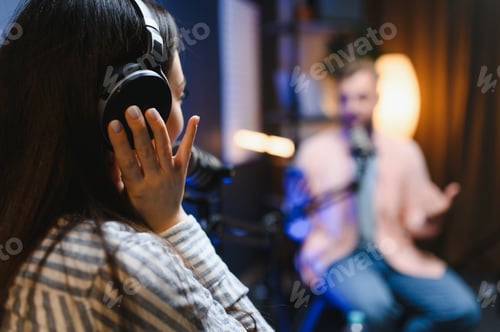 Preview: Female podcaster in headphones interviewing man guest using microphone, smiling, recording and broad
