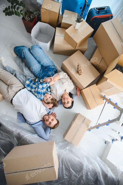 Preview: Family smiling lying on floor celebrating new home moving