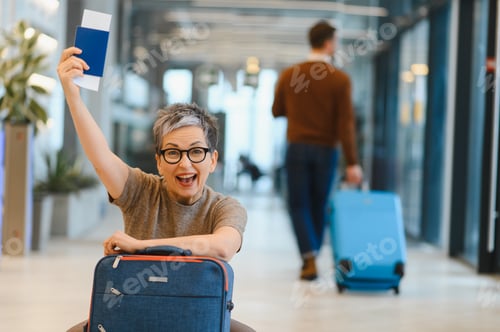 Preview: Happy woman holding passport ready for travel at airport