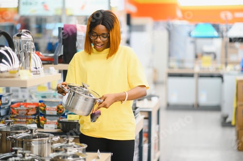 Preview: African american woman buying pan in shop cookware.