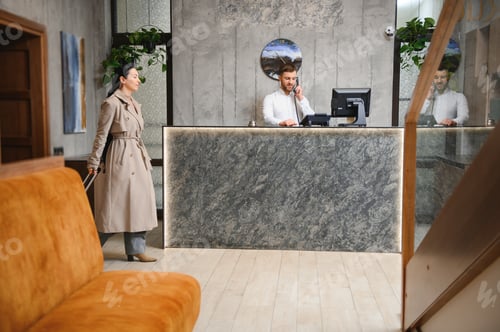 Preview: Businesswoman with luggage in modern hotel lobby