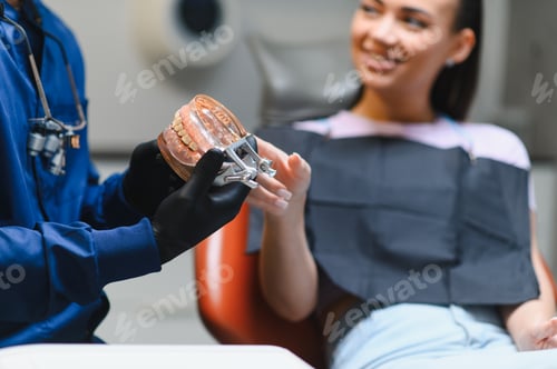 Preview: Dentist explaining dental care using a jaw model to patient