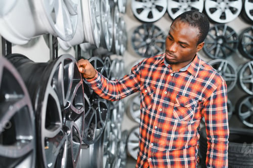 Preview: African american buyer chooses new alloy wheels for his car
