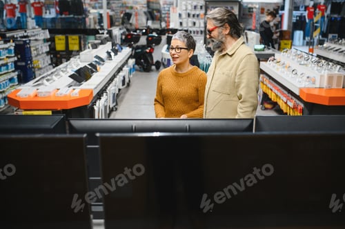 Preview: Mature couple shopping for new electronics in retail store