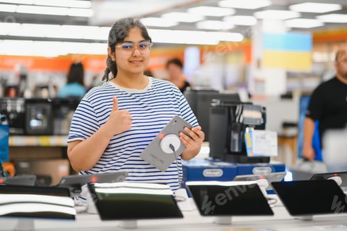 Preview: Smart modern female customer choosing coffee machine at electronics store