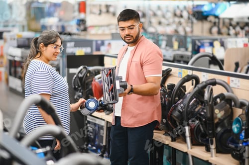 Preview: A young Indian couple buys a vacuum cleaner at an electronics store