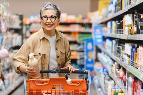 Preview: Mature woman smiling buying products in supermarket