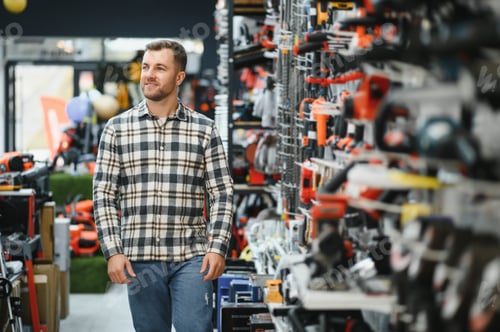 Preview: A male buyer chooses power tools in a hardware store. A large selection of tools