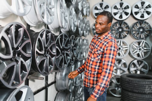 Preview: African american buyer chooses new alloy wheels for his car