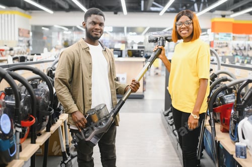 Preview: African american Couple choosing vacuum cleaner, electronics store.