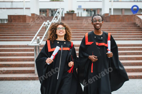 Preview: Diverse students celebrating graduation success holding diplomas