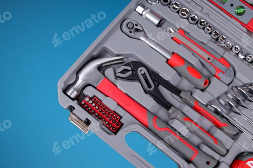 Preview: Closeup of Gray Toolbox with Claw Hammer, Adjustable Pliers, and Ratchet Wrench