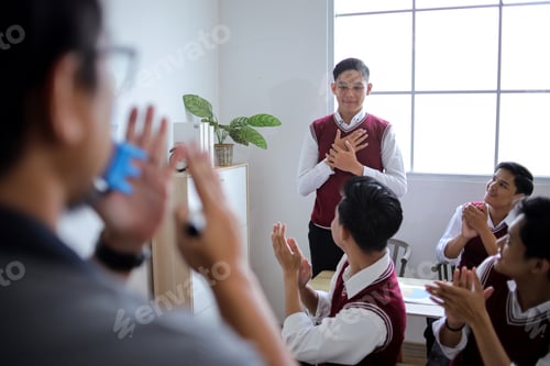 Preview: Male Teacher and Students Clapping for Boy Standing in Front of High School Class