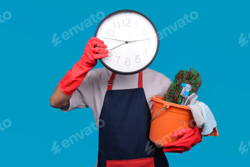 Preview: Male Cleaner Hiding Face Behind Large Wall Clock While Carrying Bucket of Supplies