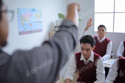 Preview: Male Student Raises His Hand to Answer Question in Classroom Setting