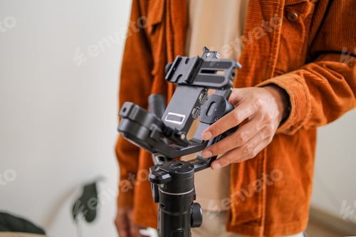 Preview: Close up of Videographer Hand Balancing Professional Camera Gimbal Stabilizer Setup Indoors