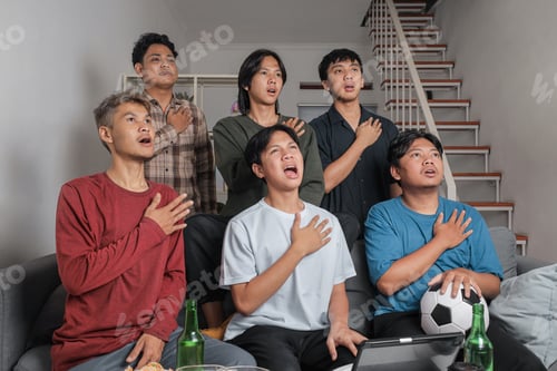 Preview: Group of Young Indonesian Men Singing National Anthem with Hands on Chest While Watching Football