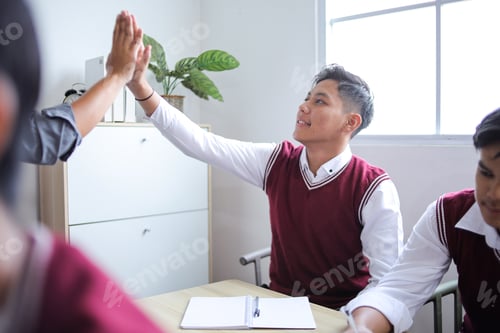 Preview: Male Asian Teacher Giving High Five to His High School Student During Cheerful Classroom Session