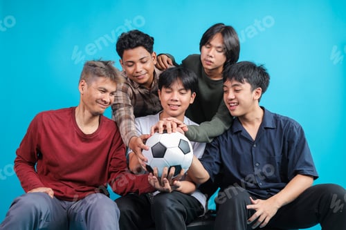 Preview: Group of Young Asian Football Fans Sitting Together, Smiling and Holding Soccer Ball